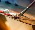PROYECTOS Vibrant artist palette with paint and brush creating colorful artwork.