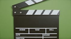 Home A classic film clapperboard on a green surface, essential for movie scenes.